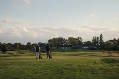 Zwei Spieler mit Trolley auf einer Golfanlage